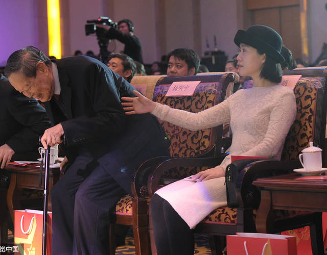 杨振宁起身，翁帆伸手帮忙。